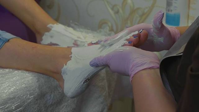 美容师在美容院做足底按摩前涂抹保湿霜视频素材