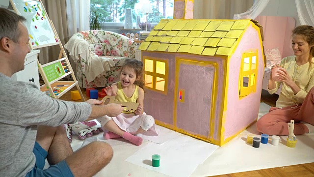 爸爸给了快乐的小女孩一把新纸板屋的钥匙视频素材