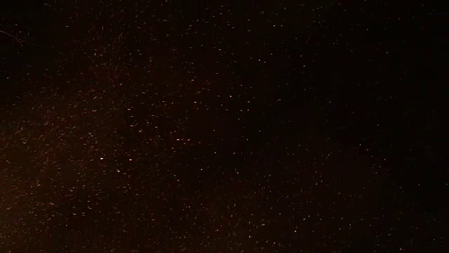 烟雾和灰烬从一个秋天的篝火漩涡通过橙色的夜晚视频下载