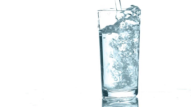 把干净的水倒进杯子里。白色背景的特写视频素材