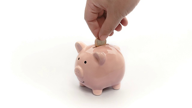 在粉色储蓄罐上存钱孤立。手把硬币放入猪娃娃银行在白色的背景。Vdo 4k, fhd，全高清，1080视频素材