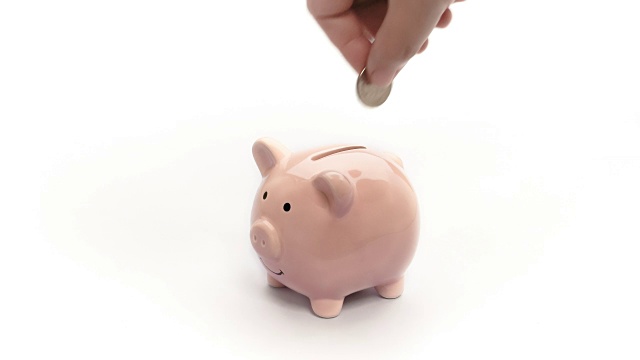 在粉色储蓄罐上存钱孤立。手把硬币放入猪娃娃银行在白色的背景。Vdo 4k, fhd，全高清，1080与文本和标题设计的复制空间背景。视频素材