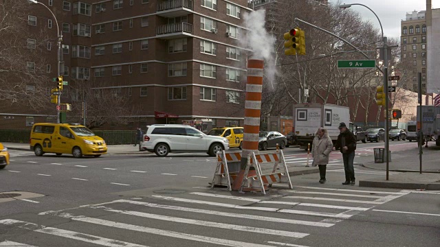 纽约市街道上的汽车和行人交通。行人使用人行横道经过蒸汽烟囱。视频素材