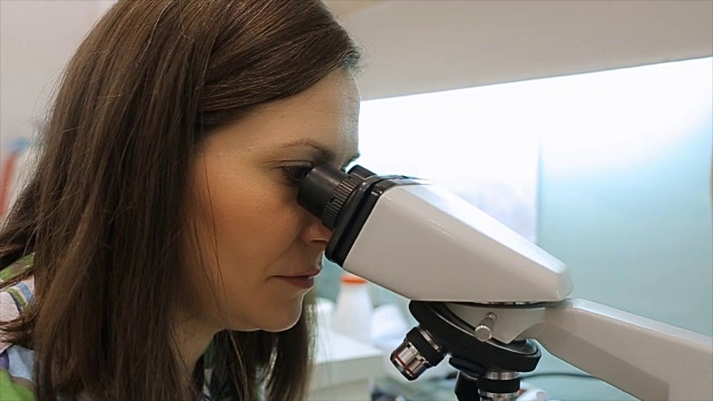 实验室人员在实验室用显微镜研究和分析化学试验。视频下载