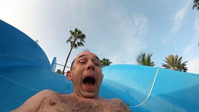兴奋的男子在水上乐园的滑水慢动作视频下载