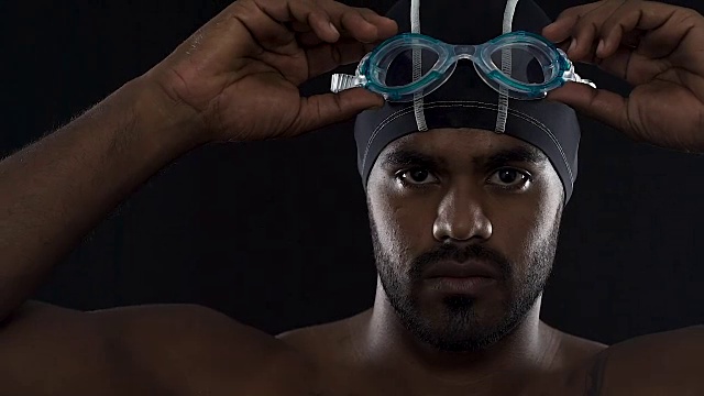积极的游泳运动员戴上护目镜，为比赛做准备视频下载