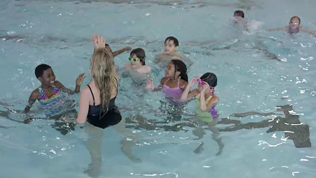游泳教练在泳池里给她的班级击掌视频下载