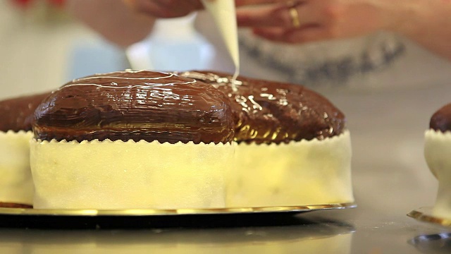 糕点师用挤花袋装饰复活节甜面包蛋糕，特写在糖果工作台上视频素材