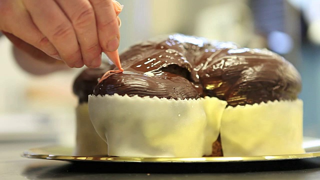 糕点师用挤花袋装饰复活节甜面包蛋糕，特写在糖果工作台上视频素材