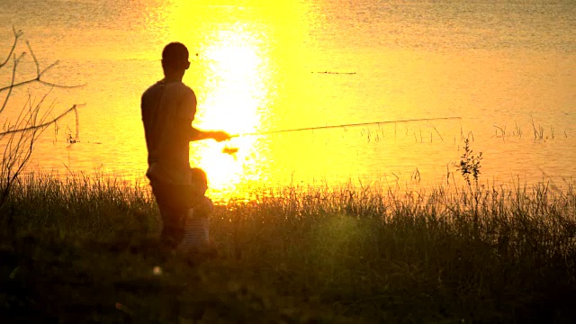 4K:父亲和儿子在日落钓鱼视频素材