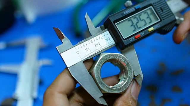 工人使用游标卡尺测量螺母的刻度视频下载
