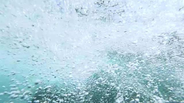 水下慢动作:难以辨认的冲浪者打破巨大的管道波浪在海洋视频素材