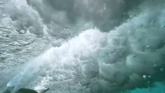 水下慢动作:不可辨认的专业冲浪者打破玻璃像管波。视频素材