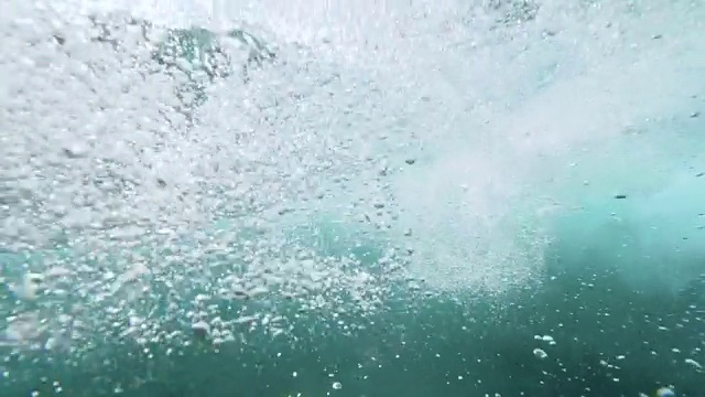 水下慢动作:不可辨认的极端冲浪者骑玻璃桶波。视频素材