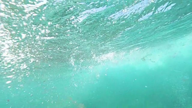 水下慢动作专业冲浪者骑着波浪在水面滑行他的手视频素材