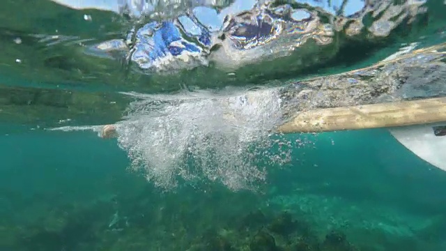 水下慢动作:极端冲浪者在清澈的水中冲浪板跳水。视频素材