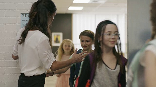 美国犹他州普罗沃，热情的老师与走出教室门口的学生击掌视频下载