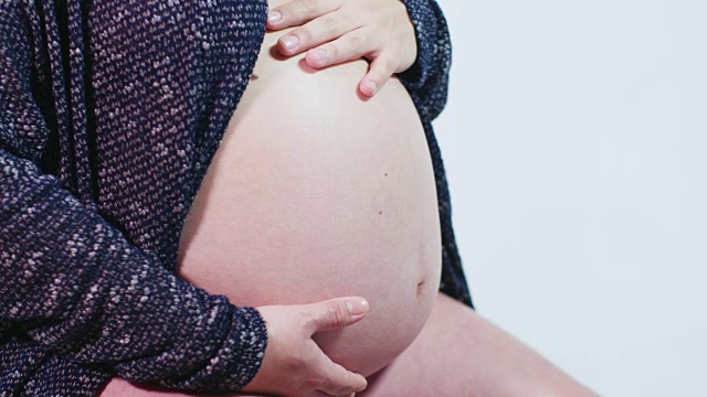 怀孕40周9个月的妈妈赤裸的肚子完整的妊娠腹部注射视频素材