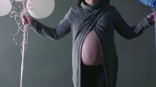女孩或男孩怀孕测试显示粉红色白色蓝色气球孕妇概念-母亲怀孕的肚子视频素材