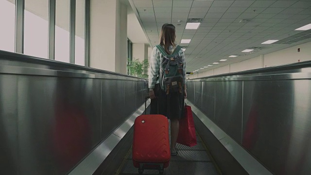 女乘客在机场的移动人行道上视频下载
