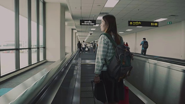 女乘客在机场的移动人行道上视频素材