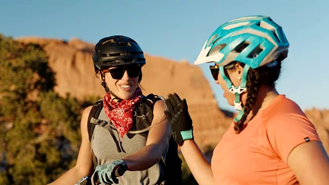 骑山地车的爱冒险的年轻女子聊着摩押小道上崎岖的地形。视频素材