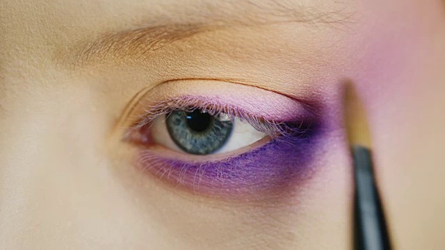 在漂亮的蓝色女性眼睛上化妆视频素材