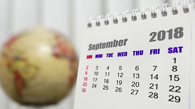 2018年9月的日历与模糊地球旋转背景的运动视频素材
