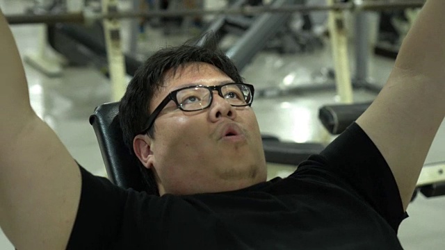平移镜头的胖亚洲人做胸部锻炼视频素材