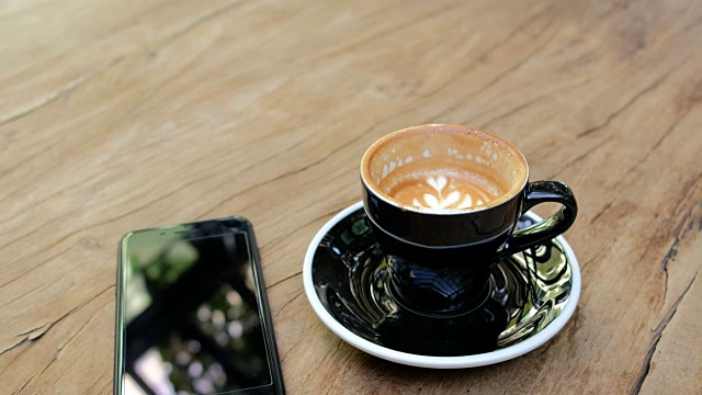 在咖啡馆的木桌上移动的咖啡杯视频下载