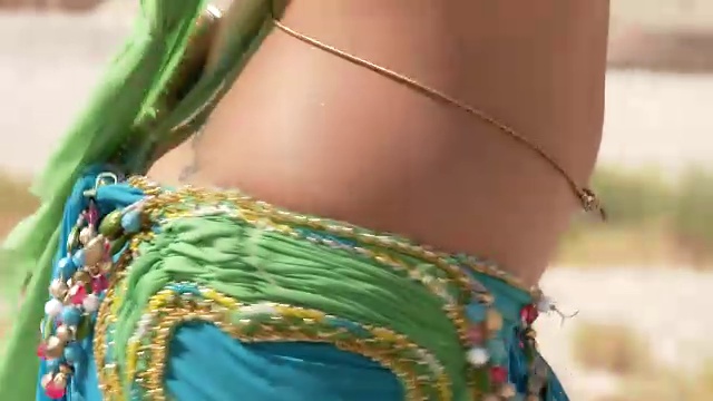 漂亮的女舞者。肚皮舞。沙漠。性感的绿蓝裙舞视频素材