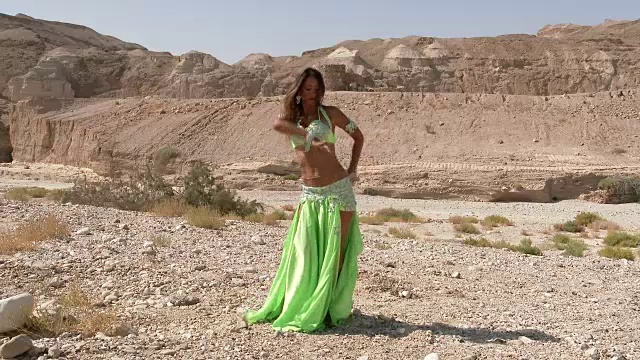 漂亮的女舞者。肚皮舞。沙漠。性感的绿裙舞。全景视频素材