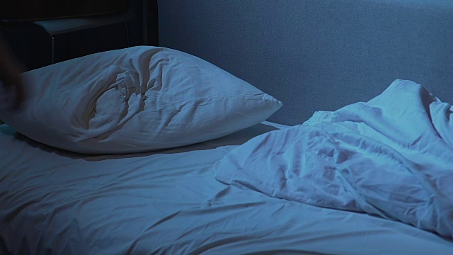 男流氓晚上回家，穿着衣服躺在床上睡着了视频素材