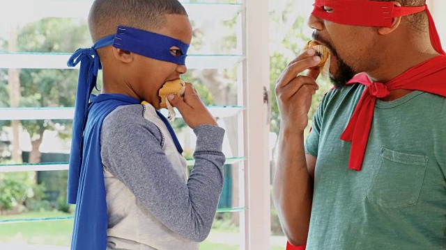 父子俩一边吃松饼一边假装自己是4k超级英雄视频素材