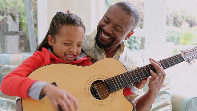 爸爸和女儿在客厅玩吉他视频素材