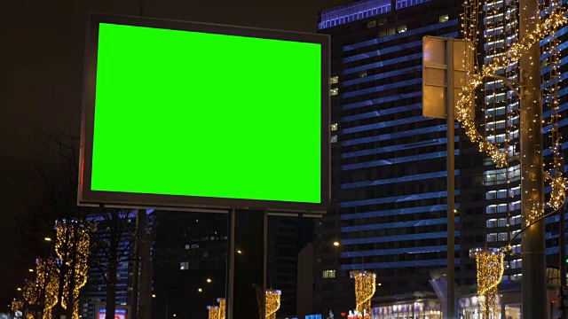 一个巨大的广告牌，在街道上，周围是美丽的照明。视频下载