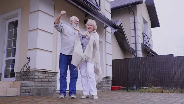 一对快乐的老夫妇，带着新房子的钥匙视频素材