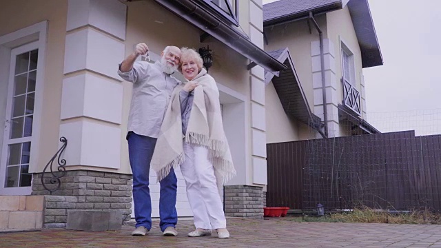 一对老夫妇刚买了栋新房子，还在摄像头上展示了钥匙视频素材