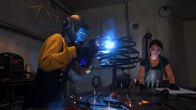 女焊工带焊接面罩使用焊机视频素材