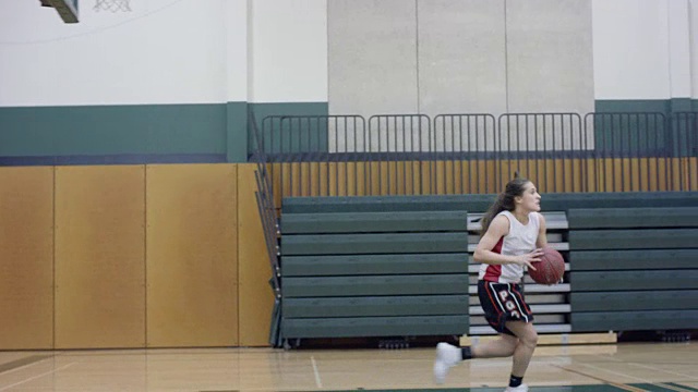 跟踪女篮球运动员在球场上运球视频素材