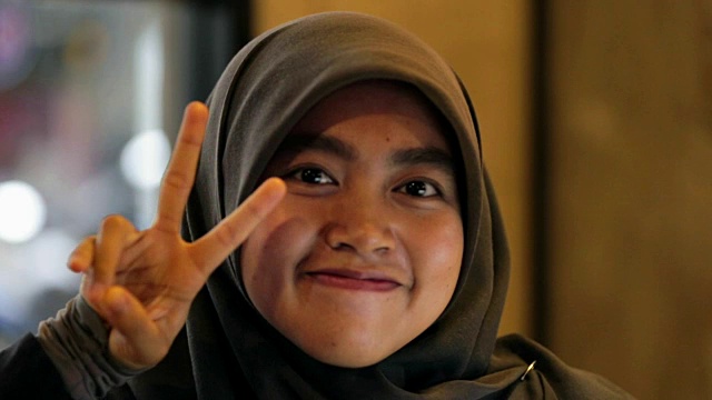 穆斯林东南亚妇女的肖像与头巾是微笑和好玩的视频下载