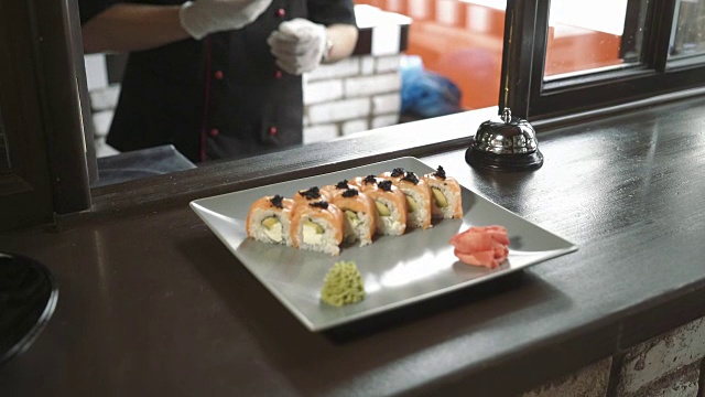 在一家餐厅或酒店的商业厨房里，专业的厨师正在提供寿司卷视频素材