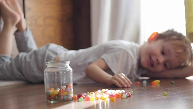 可爱的男孩在玩五颜六色的糖果视频素材
