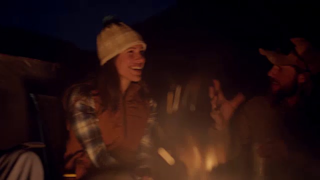 晚上，一群年轻的朋友围着闪烁的营火说说笑笑。视频下载