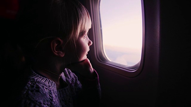 女孩坐在飞机上，看着窗外冉冉升起的太阳视频下载