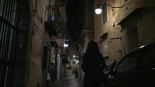 在意大利的那不勒斯，一个年轻的女人在夜里走着视频下载