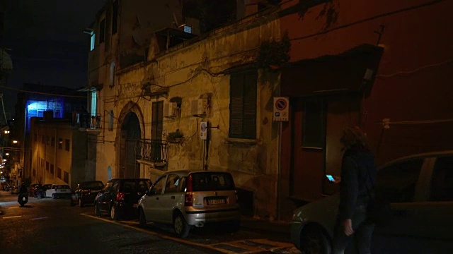 在意大利的那不勒斯，一个年轻的女人在夜里走着视频下载