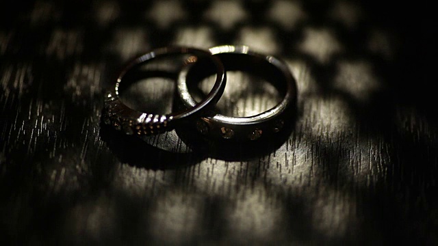 牛皮纸盒子上的两个结婚戒指。黑暗的场景视频下载