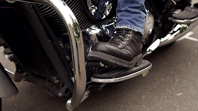 在摩托车上穿着靴子的脚夫的特写。视频素材
