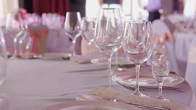 宴会或婚宴上的餐桌。豪华优雅的餐桌设置在餐厅晚餐。眼镜和菜肴。视频素材